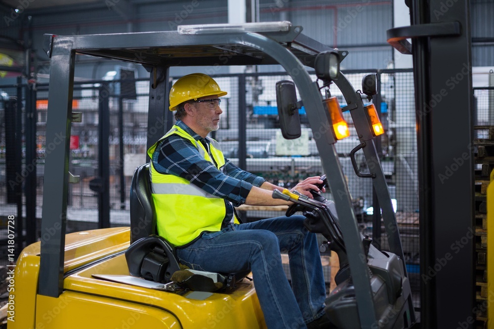 Factory worker driving forklift Factory worker driving forklift