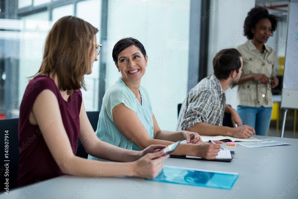 Smiling business executives interacting with each other during meeting Smiling business executives interacting with each other during meeting