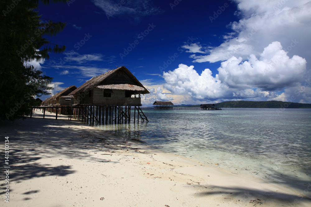 Water bungalows. island Kri, Raja Ampat marine reserve , Indonesia -11 December 2012 , the bungalows on stilts on the water and white sand beach and mangroves directly to the ocean Water bungalows. island Kri, Raja Ampat marine reserve , Indonesia -11 December 2012 , the bungalows on stilts on the water and white sand beach and mangroves directly to the ocean