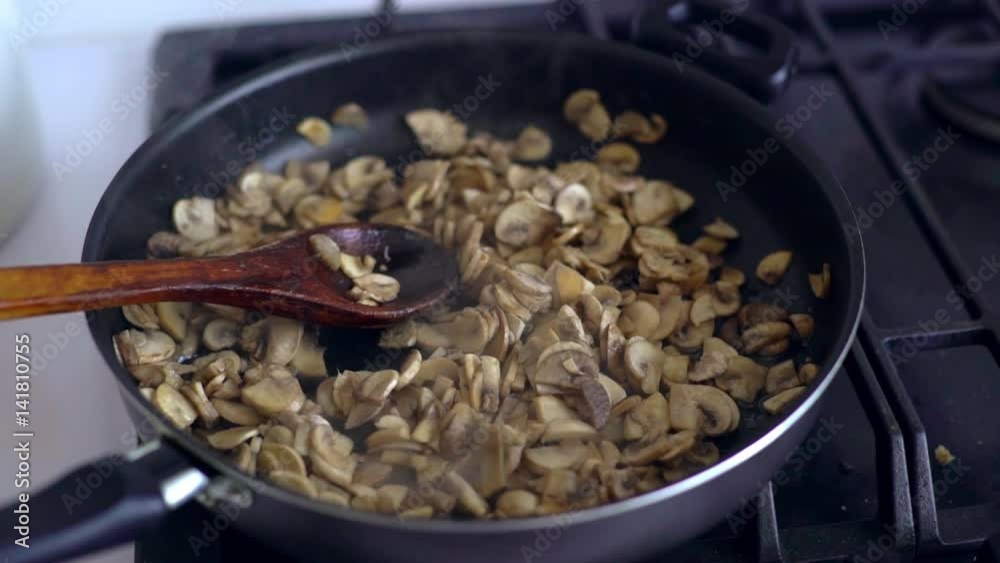 Frying mushrooms.Mushrooms cut into pieces fried in a frying pan. Delicious fried mushrooms in pan close-up Frying mushrooms.Mushrooms cut into pieces fried in a frying pan. Delicious fried mushrooms in pan close-up