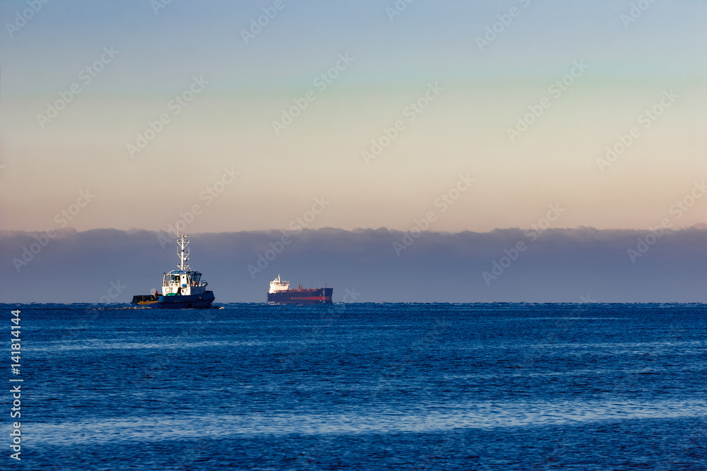 Blue small tug ship leaving Riga and entering the Baltic sea