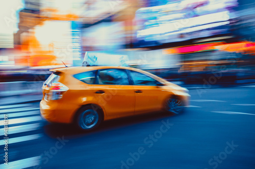 Abstract motion blurred New York City taxi driving fast on city street blurred background