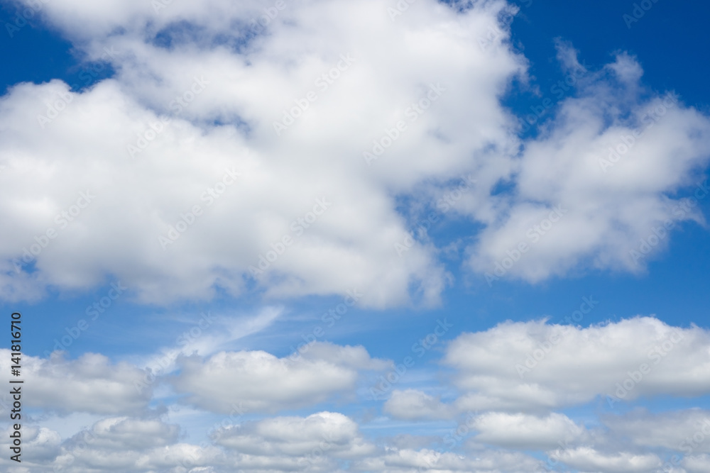 Blue sky with clouds over horizon. White clouds against blue sky. Blue sky with clouds over horizon. White clouds against blue sky.