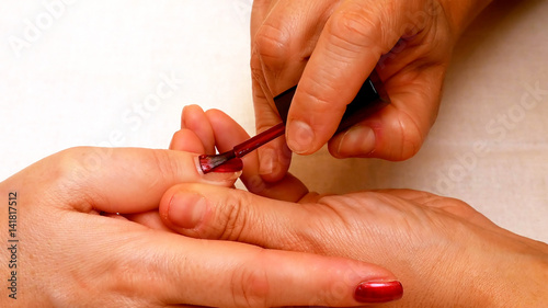 Manicure in the beauty salon. Painting and polishing nails. Spa nails cuticle scarfskin procedure.
