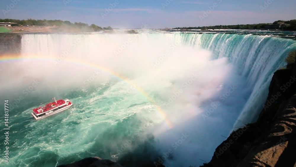 Boat Full of Tourists Gets Sprayed by Horseshoe Waterfall Under Rainbow in Niagara Falls Ontario Canada