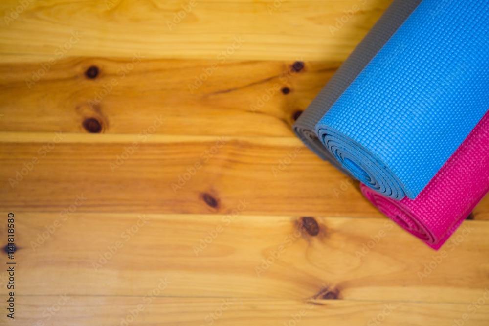 Rolled-up exercise mat on wooden floor Rolled-up exercise mat on wooden floor