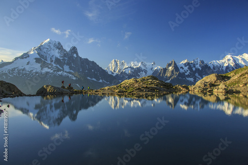 Photographers and hikers on the shore of Lac De Cheserys at dawn Haute Savoie France Europe photo