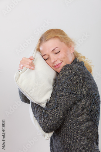 Happy sleepy woman holding cozy pillow