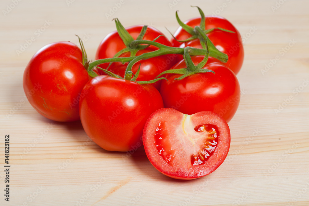 organic red tomatoes with the stem on the wood table organic red tomatoes with the stem on the wood table