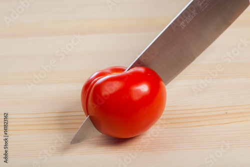 Cutting tomatoes for dishes on the table. Vegetables during the cooking process dishes. Vegetables for healthy eating and dieting photo