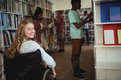 Disabled girl on wheelchair in library