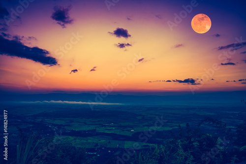 The full moon in the evening after sunset. Outdoors at nighttime. Vintage effect tone.
