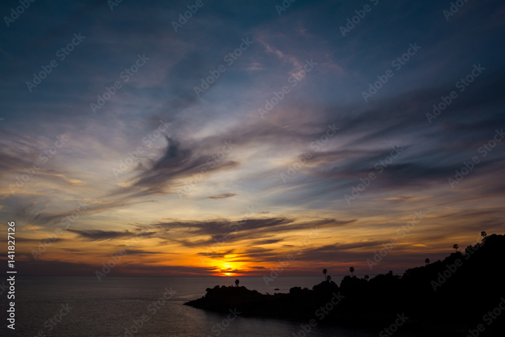 Cloudy sky and the shoreline in sunset. The cloudy sunset and the silhouette of shoreline. Horizontal outdoors shot.