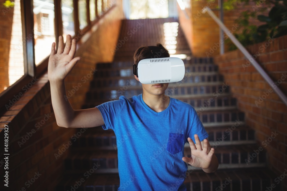 Schoolboy using virtual reality headset on staircase Schoolboy using virtual reality headset on staircase