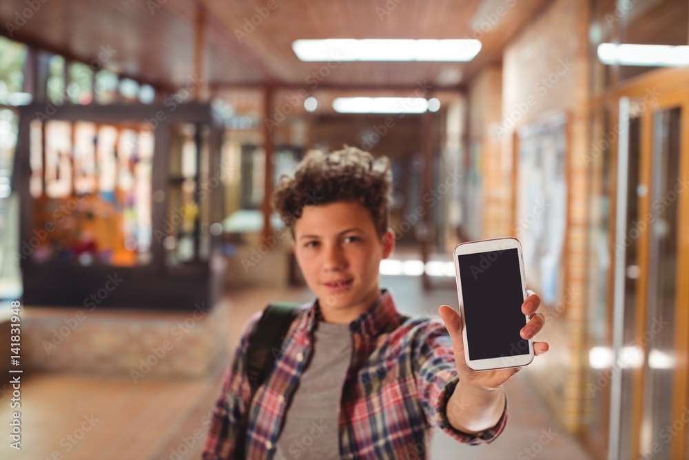 Schoolboy standing showing mobile phone Schoolboy standing showing mobile phone