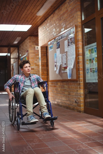 Disabled schoolboy on wheelchair in corridor