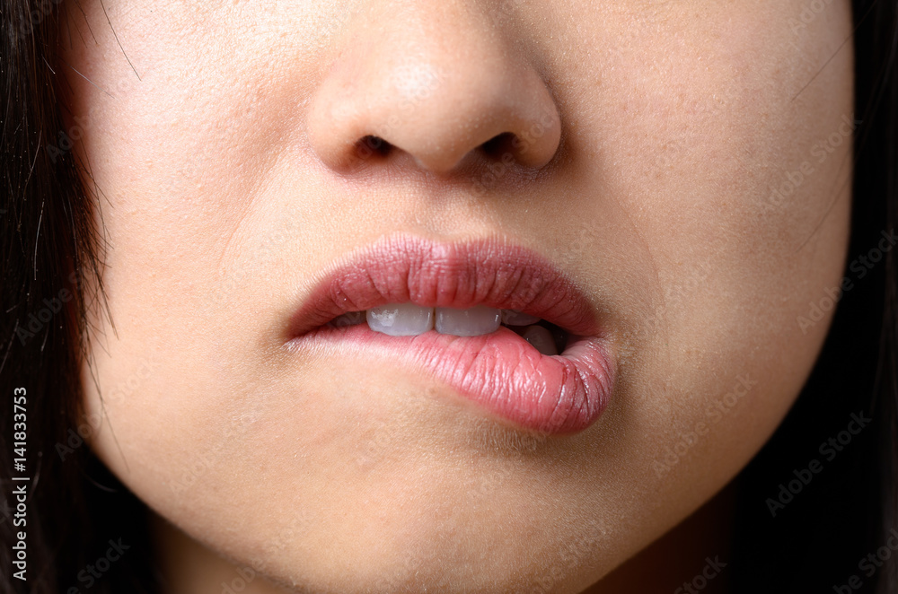 Naklejka premium Thoughtful woman biting her lip