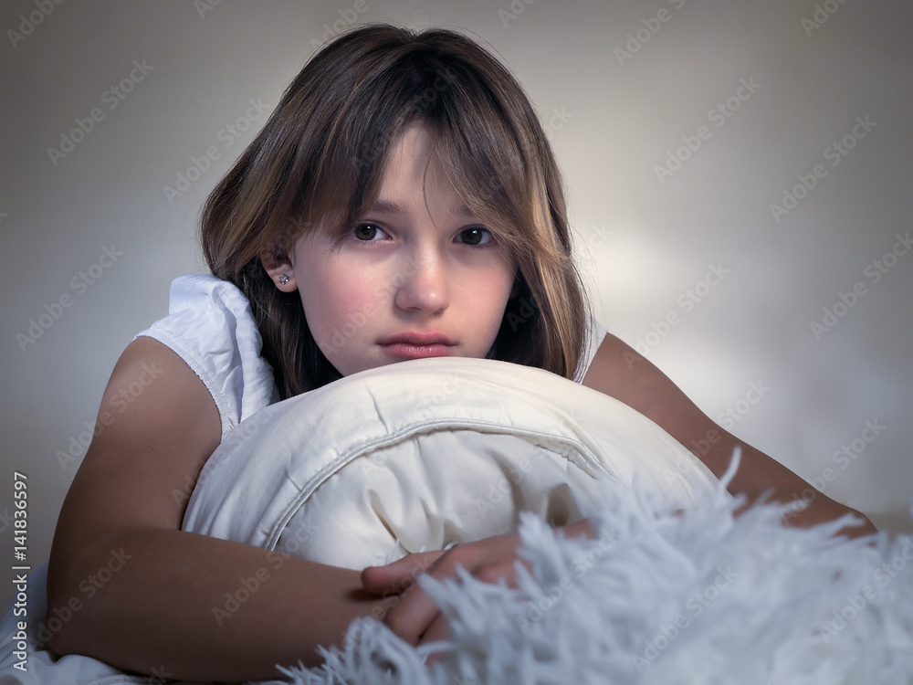 Sad girl on the bed hugging a pillow. Portrait Stock Photo | Adobe Stock