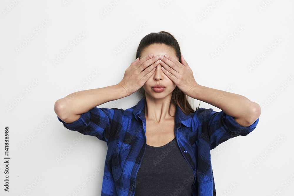 Brunette woman with hands covering eyes, studio Brunette woman with hands covering eyes, studio