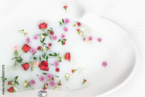 mix flower petals and leaves in milk bath, background or texture for massage and spa, relax  photo
