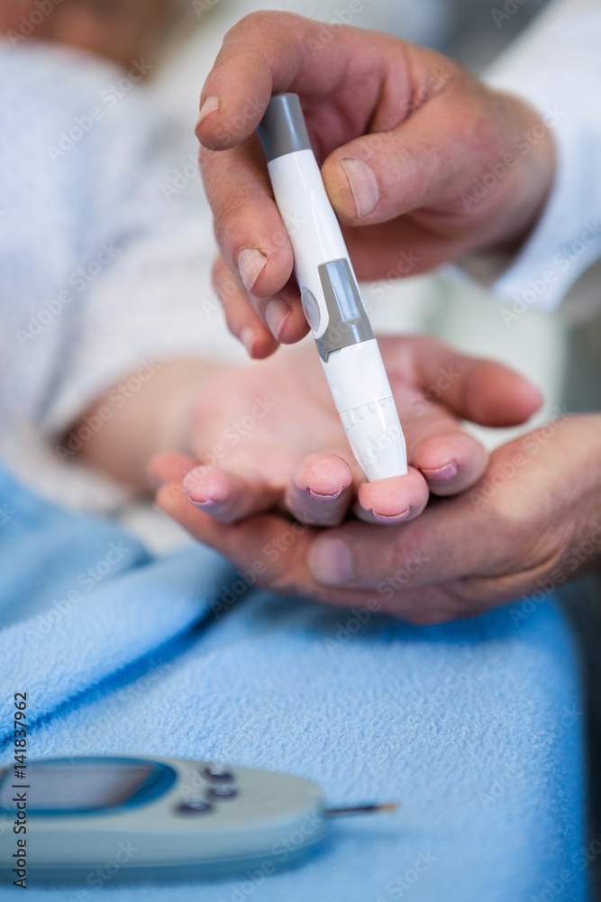 Doctor testing diabetes of senior patient with insulin pen Doctor testing diabetes of senior patient with insulin pen
