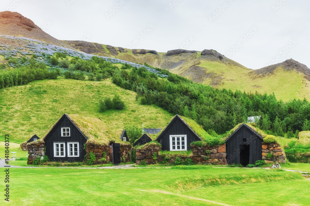 A small wooden church and cemetery Hofskirkja Hof, Skaftafell Iceland. Scenic sunset through tree crowns