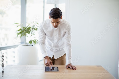 Business executive using digital tablet at desk