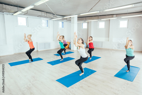 women are practicing yoga exercises in the studio. itness, sport, people and healthy lifestyle concept © kaninstudio