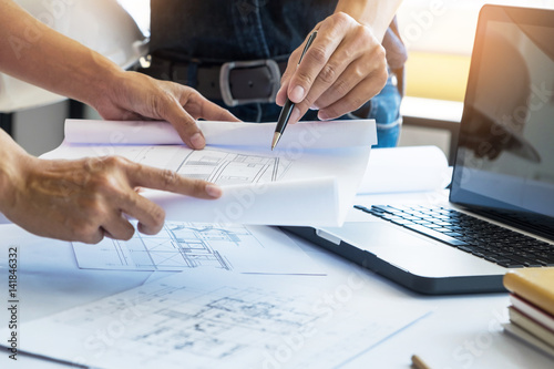 Foto Architects engineer discussing at the table with blueprint - Closeup on hands an