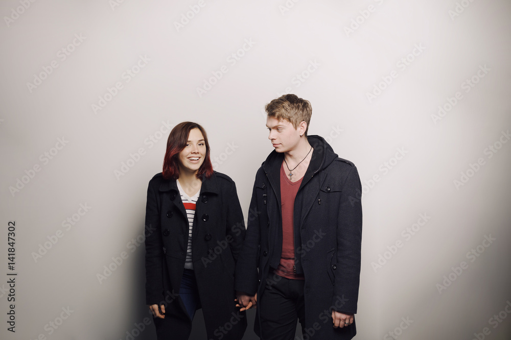 Happy young couple in winter clothes having fun in studio over white background Happy young couple in winter clothes having fun in studio over white background