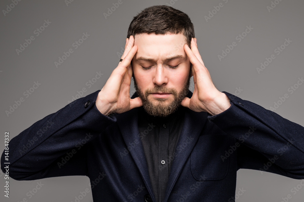 Sad businessman head in hands frowning with headache Sad businessman head in hands frowning with headache
