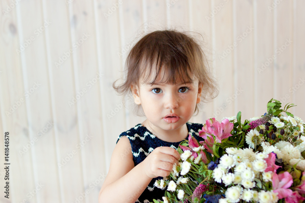 baby girl with a bouquet of flowers in Studio baby girl with a bouquet of flowers in Studio