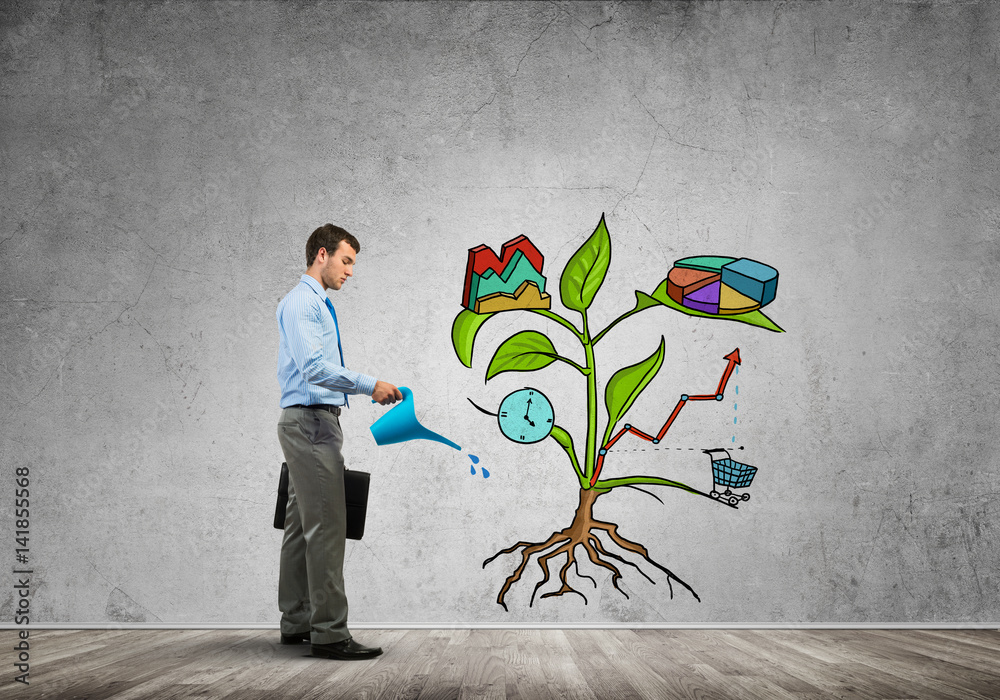 Young businessman in empty room watering drawn growth concept with can Young businessman in empty room watering drawn growth concept with can