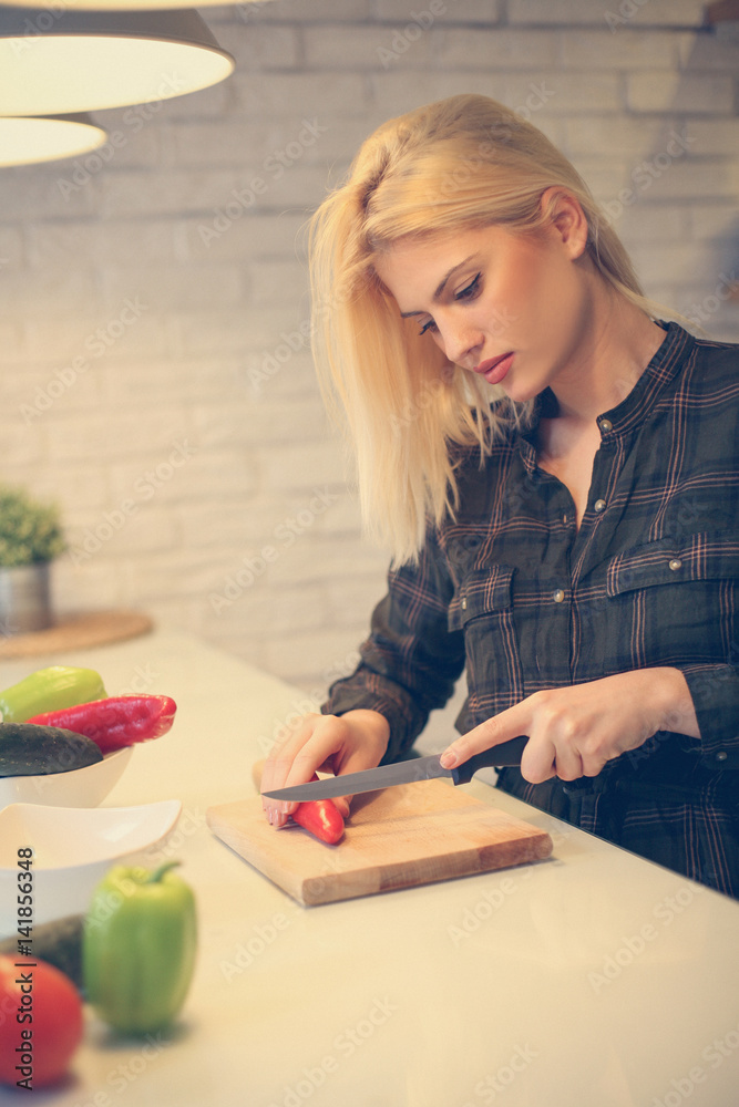 Young woman cooking vegetable salad at home. Young woman cooking vegetable salad at home.