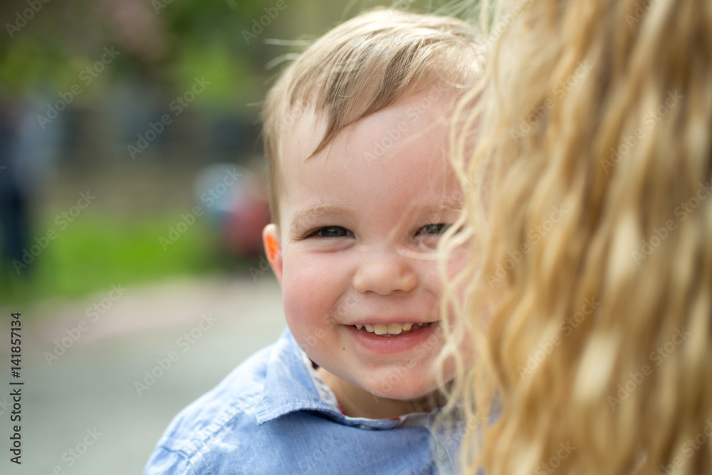 Cute happy baby boy smiling in mother arms Cute happy baby boy smiling in mother arms