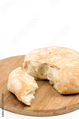 Round domestic bread sliced on the wooden board