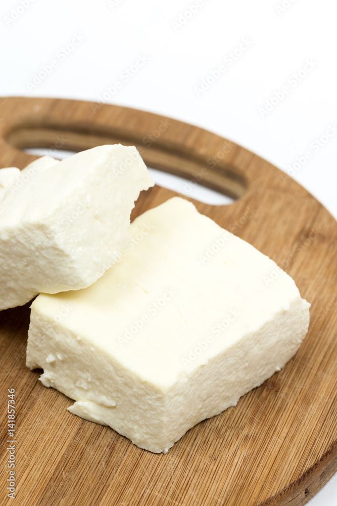 Slices of white feta cheese on the wooden board