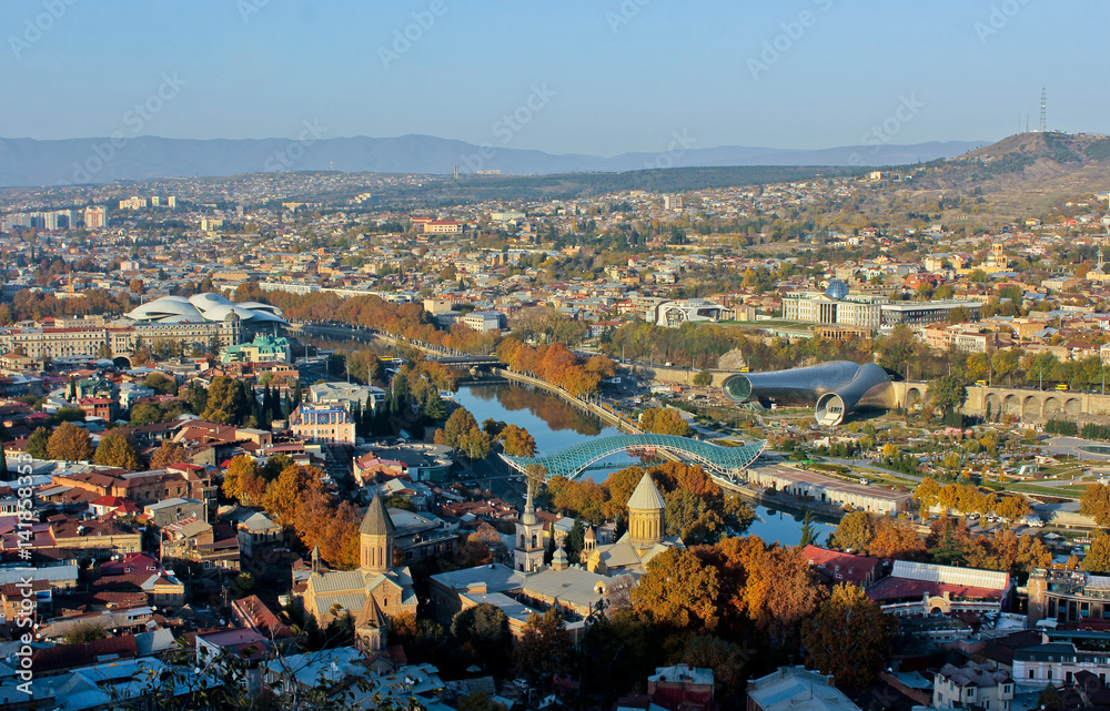 Autumn view to historical part of the capital of Republic of Georgia. In front two churchs Zion Cathedral and Jvaris Mama. In the middle river Kura, Bridge of Peace. 