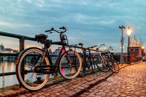 Evening view of parked bicycles alongside the Dutch river Maas