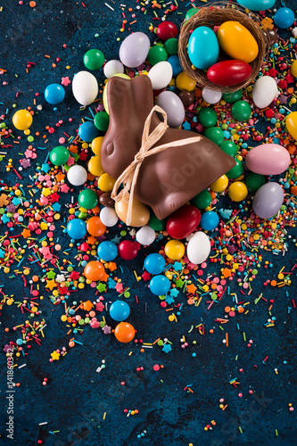 Delicious chocolate easter eggs ,bunny and sweets on dark blue background