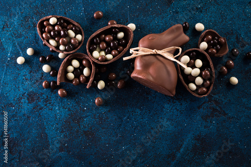Delicious chocolate easter eggs ,bunny and sweets on dark blue background