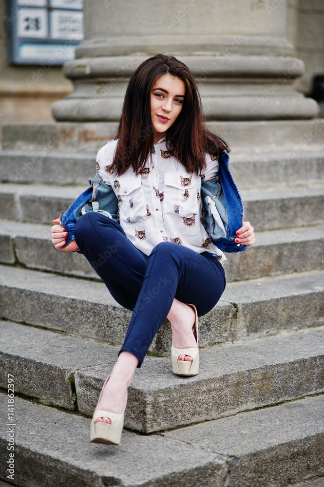 Young stylish brunette girl on shirt, pants, jeans jacket and high heels shoes, posed at stone stairs. Street fashion model concept. Young stylish brunette girl on shirt, pants, jeans jacket and high heels shoes, posed at stone stairs. Street fashion model concept.