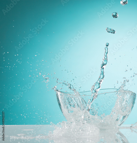 The water splashing to glass bowl on white background