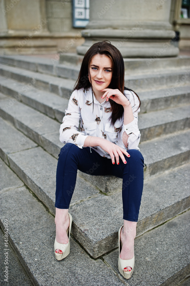 Young stylish brunette girl on shirt, pants and high heels shoes, posed at stone stairs. Street fashion model concept. Young stylish brunette girl on shirt, pants and high heels shoes, posed at stone stairs. Street fashion model concept.