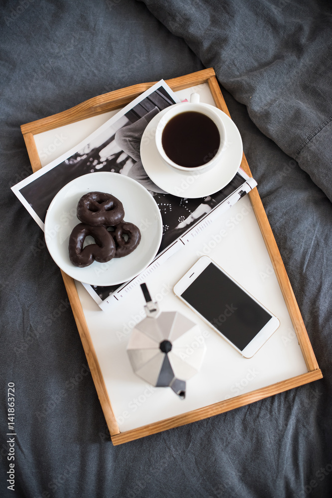 Coffee and breakfast in bed, smartphone and magazine Coffee and breakfast in bed, smartphone and magazine
