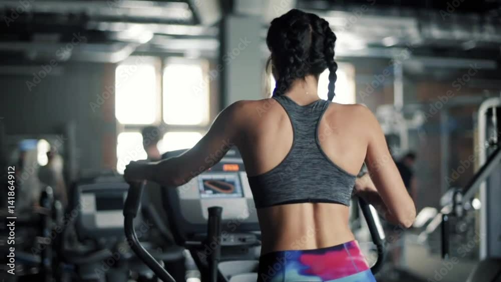 Fit woman training in elliptical trainer Fit woman training in elliptical trainer