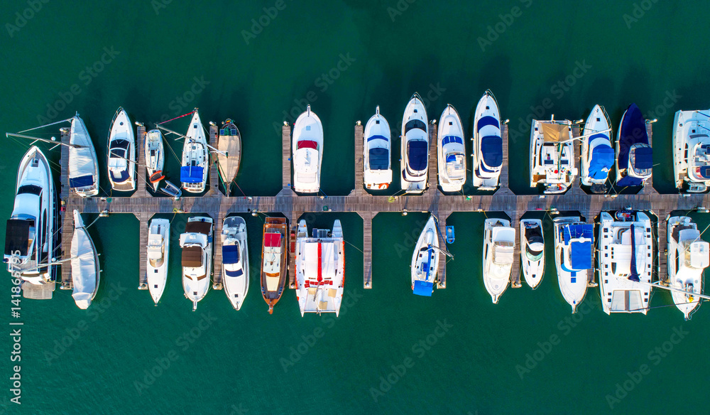 Obraz premium Pier speedboat. A marina lot. This is usually the most popular tourist attractions on the beach.Yacht and sailboat is moored at the quay.Aerial view by drone.Top view.