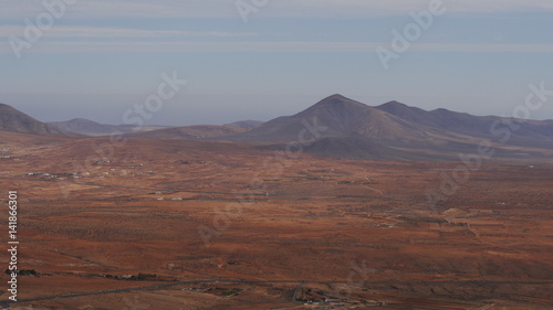 A look at the volcanic landscape - a desert in brown and red colors in the central part of the island Fuerteventura, Canary Islands, Spain.