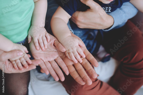 Father s and mother hands holding  hands children.Father and Mother Holding twins children. Child hands Closeup into Parents