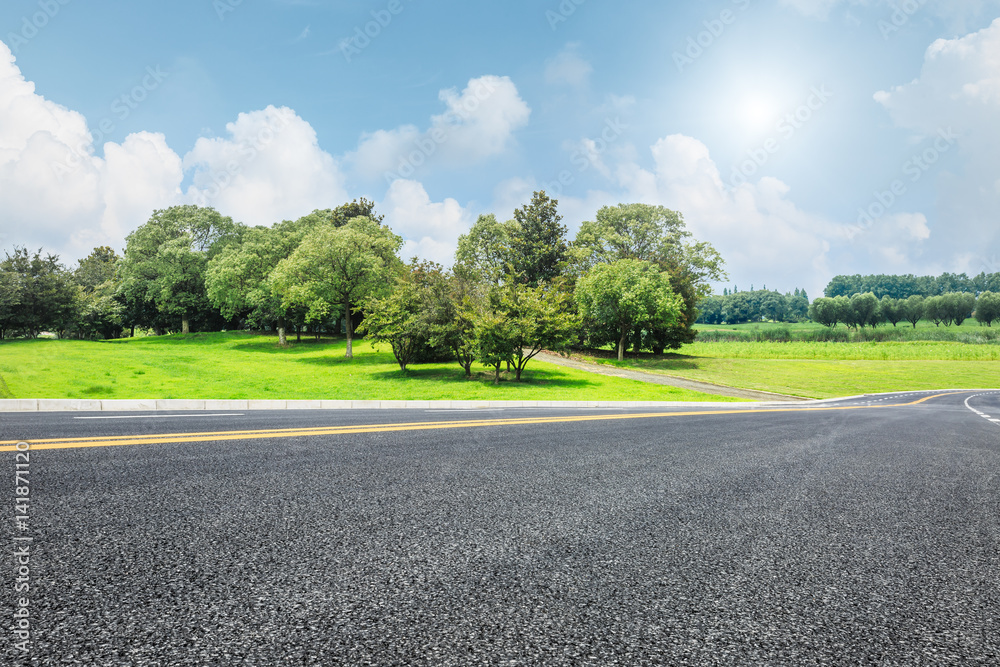 Asphalt road and green trees in the blue sky Asphalt road and green trees in the blue sky